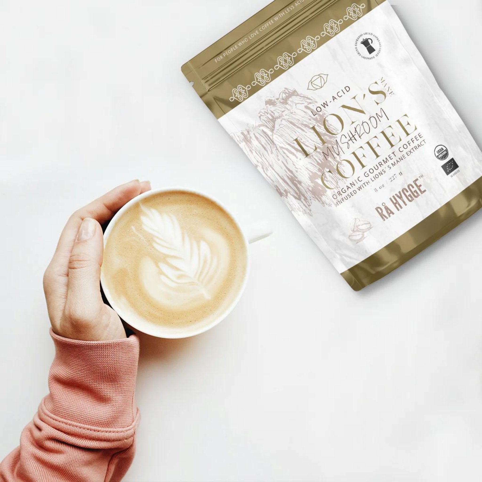 A cup of coffee next to the Organic Lion’s Mane mushroom coffee package. 